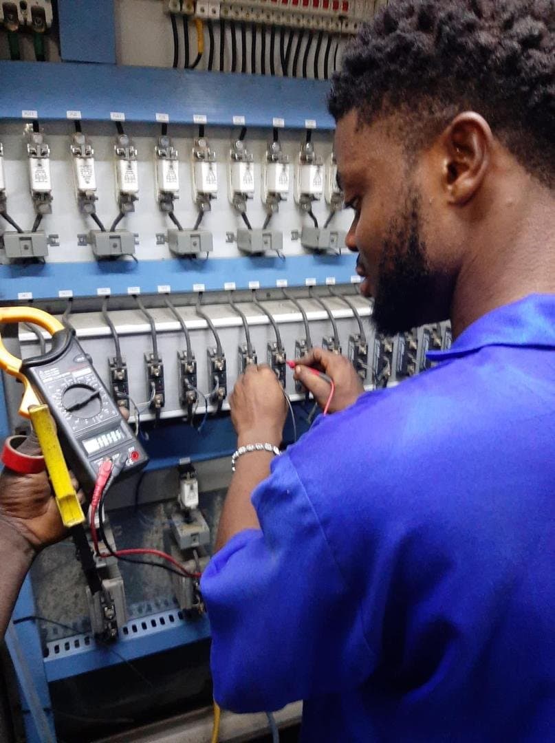 Technician testing an electrical control panel